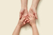 © Yaroslav Danylchenko/Stocksy - Tender mother's hands holding little kid's hands.