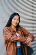 © Ezequiel Giménez/Stocksy - Smiling Asian female in jacket on street