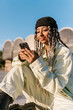 © Ezequiel Giménez/Stocksy - Stylish woman reading messages on smartphone in city