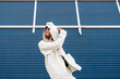 © Ezequiel Giménez/Stocksy - Cheerful woman covering face with arms on street