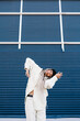© Ezequiel Giménez/Stocksy - Calm woman dancing against blue building