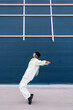 © Ezequiel Giménez/Stocksy - Energetic woman dancer performing moves on city street