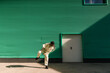 © Ezequiel Giménez/Stocksy - Woman dancing hip hop near green wall