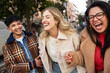 © Edward Córdoba/Stocksy - Friends walking together in the city center, laughing and smiling.