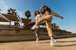© Javier Díez/Stocksy - Trendy young women dancing in park in sunlight
