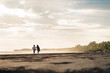 © Santi Nuñez/Stocksy - Silhouette girls on sandy beach