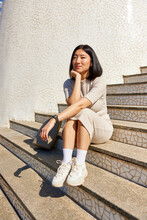 Asian Woman Sitting On City Stairs