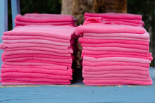 Pink Towels Stacked Up On Blue Surface