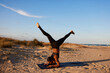 © Javier Díez/Stocksy - Anonymous woman performing yoga pose on sandy beach