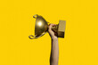 © Pixel Stories/Stocksy - Winner holding golden cup. Success and achievement, victory concept.