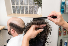 Woman Hairdresser Combing Hair Prosthesis Before Fitting It To The Cus