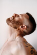 © Lucas Ottone/Stocksy - Portrait of bearded man stretching his neck