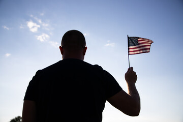 Wall Mural - Man holding a waving american USA flag.