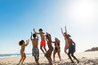 © BONNINSTUDIO/Stocksy - Group of friends having fun on beach