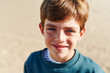 © Ivan Gener/Stocksy - Smiling boy playing on a beach