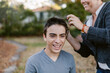 © ByLorena/Stocksy - Teenager Getting Buzz Haircut by Mom Outdoors