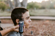 © ByLorena/Stocksy - Teen boy giving a buzz cut portrait
