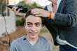 © ByLorena/Stocksy - Happy teenager boy shaving hair outside home
