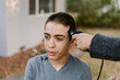 © ByLorena/Stocksy - Teen boy giving a buzz cut portrait