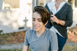 © ByLorena/Stocksy - Happy teenager boy shaving hair outside home