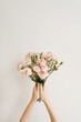Girl's hands holding carnation flowers bouquet. Flat lay, top view. Floral composition