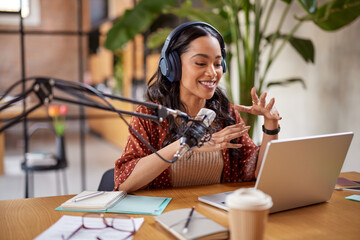 Smiling young latin woman recording podcast