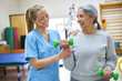 © Robert Kneschke - Therapist assisting senior woman exercising with dumbbells