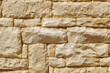 Texture of supporting stone retaining wall with yellow brick stone. Sandstone close-up