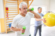 © Robert Kneschke - Elderly man exercising with dumbbells at rehabilitation center