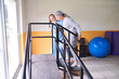 © Robert Kneschke - Physiotherapist assisting senior woman in climbing ramp