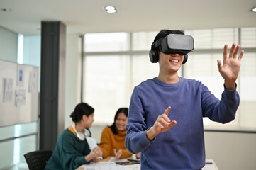 Wall Mural - a cheerful and excited asian male developer tested a new vr game on a vr headset