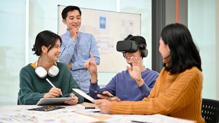 Wall Mural - a male developer sitting at the table tested a new vr game with virtual reality goggles