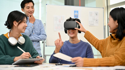 Wall Mural - a team of asian developers is in the meeting and excited about their newly developed vr game