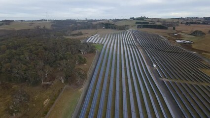 Wall Mural - aerial drone pullback reverse view of a hybrid wind and solar farm for renewable clean energy supply