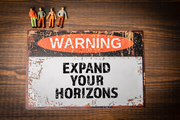 Wall Mural - Expand your horizons. Warning sign with text on wood texture background