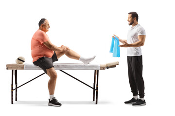 Wall Mural - Physical therapist showing exercise to a mature man with an injured knee