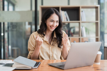 Happy asian business woman employee celebrating while reading email good news. business account and finance