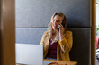 © WavebreakMediaMicro - Happy plus size caucasian casual businesswoman using laptop and talking on phone at desk