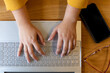 © WavebreakMediaMicro - Overhead view of hands of plus size caucasian casual businesswoman using laptop at desk