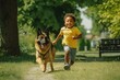 dark-skinned child runs for a walk next to a dog in a summer park