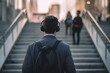 © Svante Berg - Rear view of young man wearing headphones walking in stairs at train station