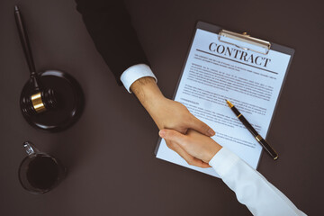 Canvas Print - Top view lawyer or attorneys colleagues handshake after successful legal discussing on contract agreement for lawsuit to advocate resolves dispute in court ensuring trustworthy partner. Equilibrium