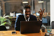 © JustLife - Portrait of successful businessman in office. Young smiling man using the laptop..