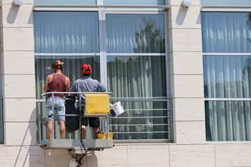 Window washers working outdoor on a lift