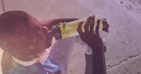 Wall Mural - Animation of glowing lights over an exercising african american man drinking water