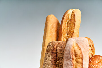 Wall Mural - Different types of french bread baguettes in paper bag over white background with copy space