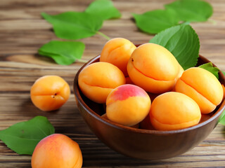 Wall Mural - bowl of fresh ripe apricots with leaves. Made with generative ai
