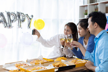 Wall Mural - Let the party begin! Group of young people having fun together with champagne and pizza. Celebrating holiday in company office with friends. Young friends taking selfies together at home party.