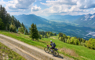 Wall Mural - active senior woman on a mountain bike tour in the carinthian alps above Villach in Austria