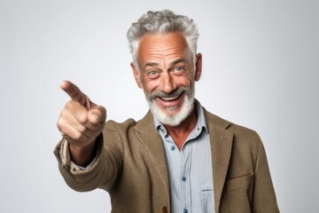 Poster - Lifestyle portrait photography of a grinning mature man making a i see you gesture pointing at one's eyes against a white background. With generative AI technology